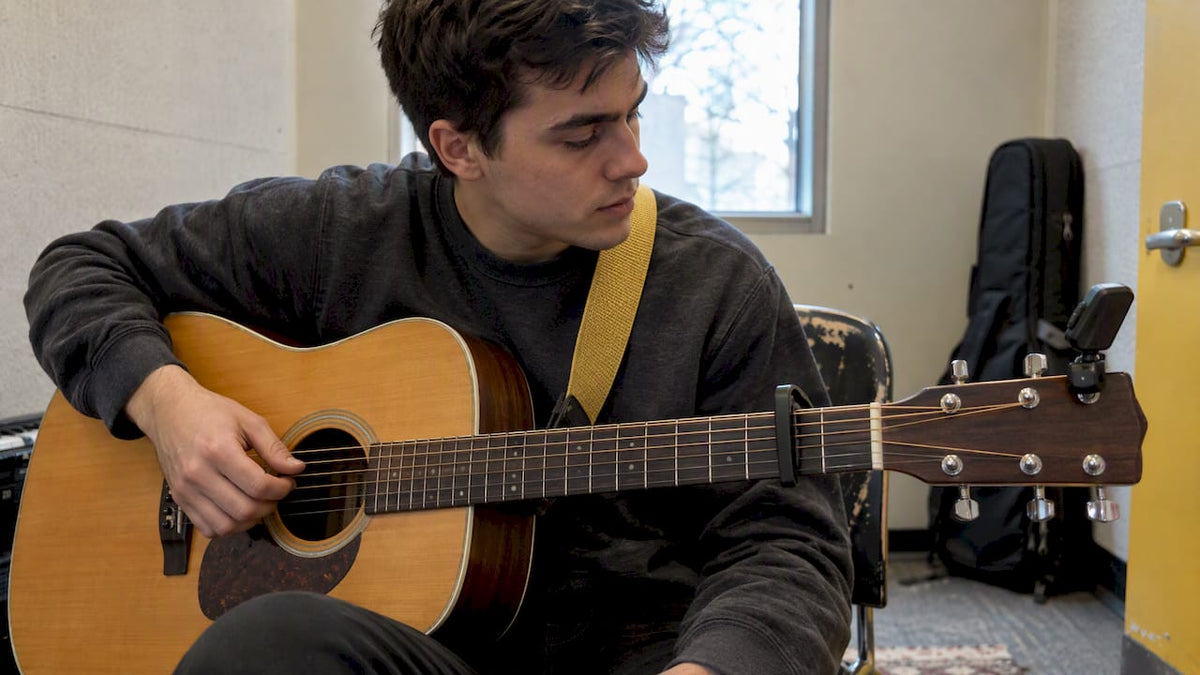 Beginner checking an acoustic guitar with capo