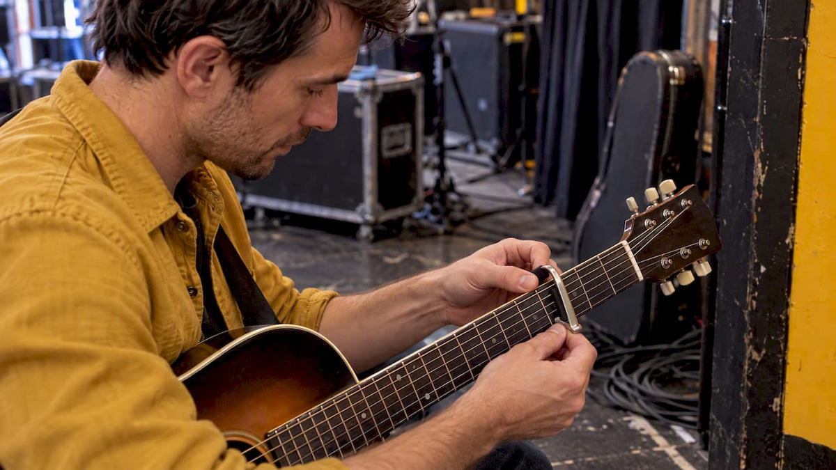 Guitarist fitting a capo before playing