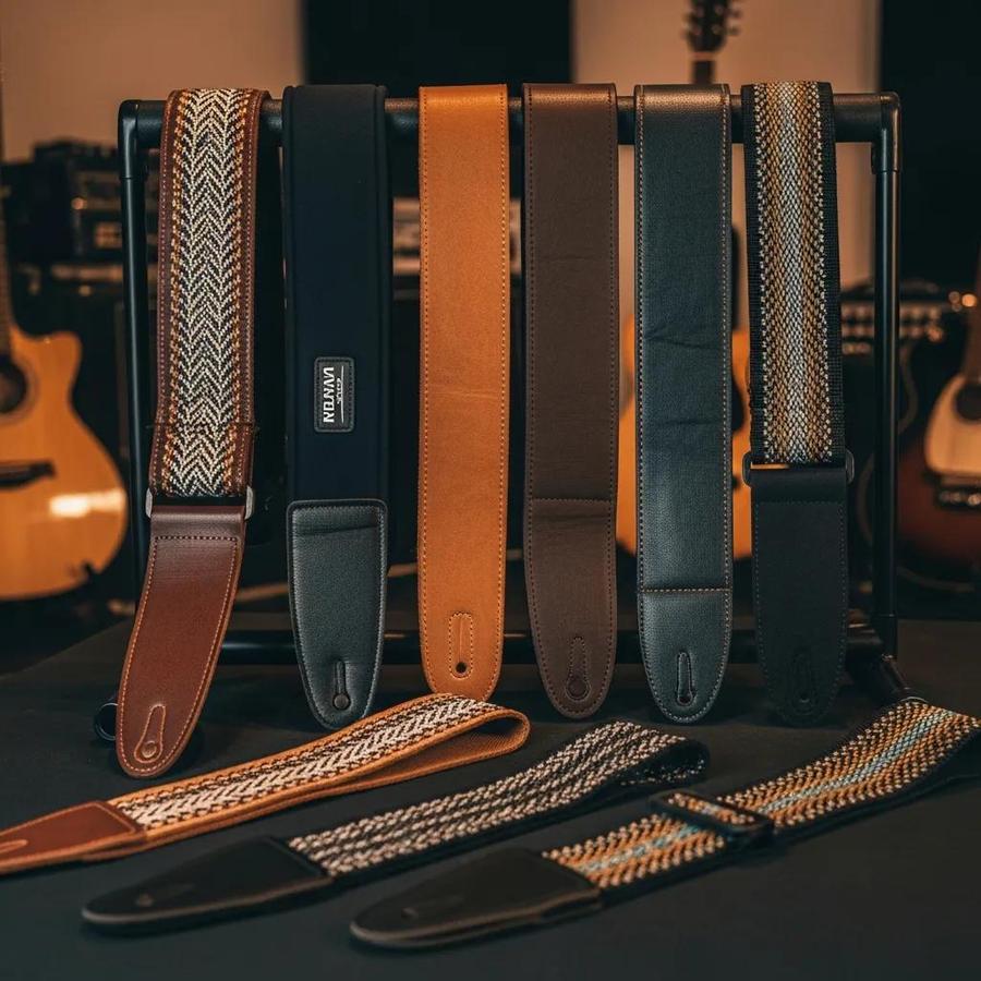 Variety of guitar straps displayed in a music studio, showcasing different materials and styles