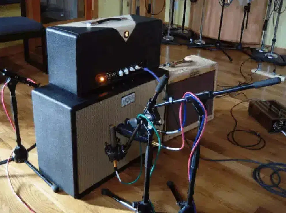 Image of guitar amplifiers showcasing a small vs big music comparison during a recording session.