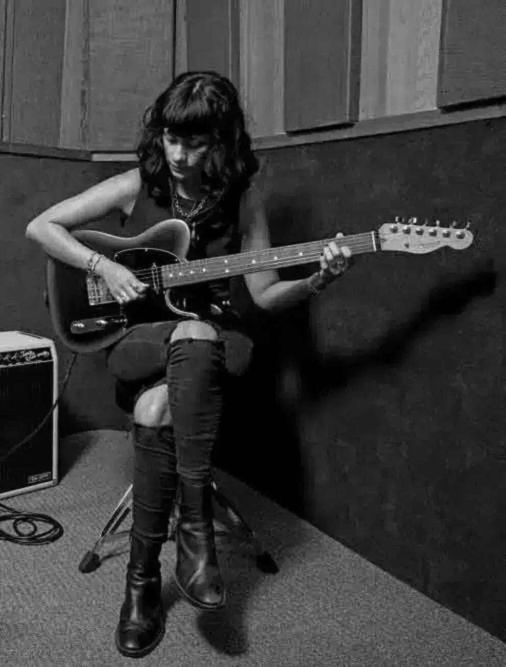 A guitarist playing a Fender Telecaster, showcasing skills in a studio setting. Fender Telecaster guide.