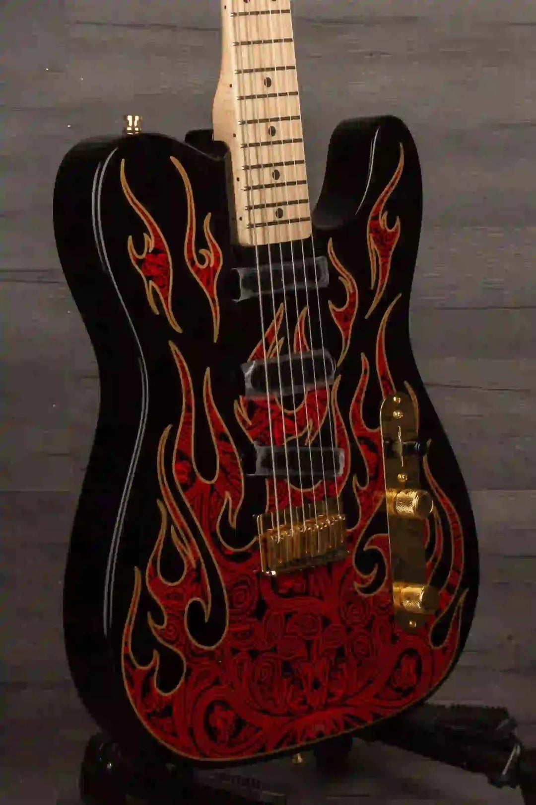 Custom black guitar with flame design and gold hardware, perfect for rock music enthusiasts.