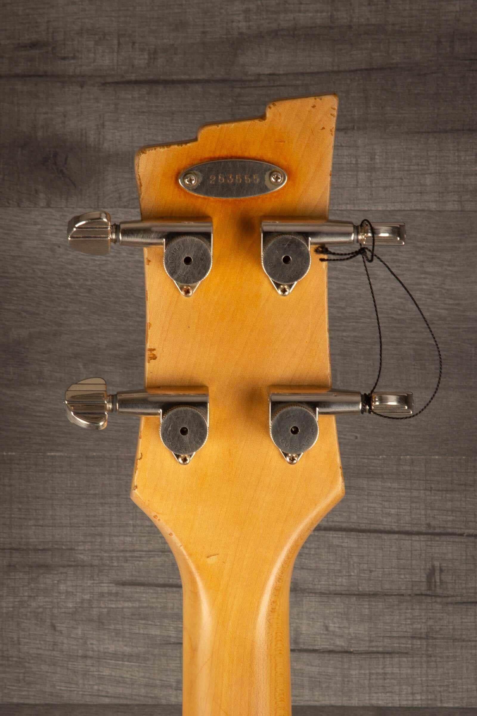 Duesenberg Chris Chaney Bass Black Distressed LTD headstock with tuning pegs on solid wood background.