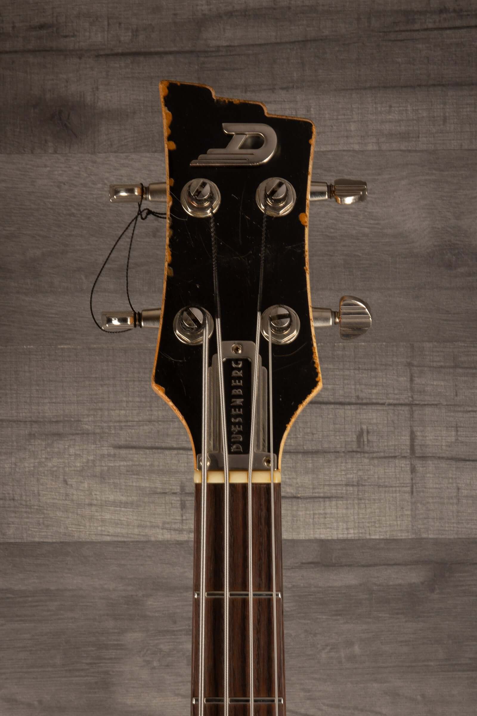 Duesenberg Chris Chaney Bass Black Distressed LTD headstock featuring vintage design and aged finish.