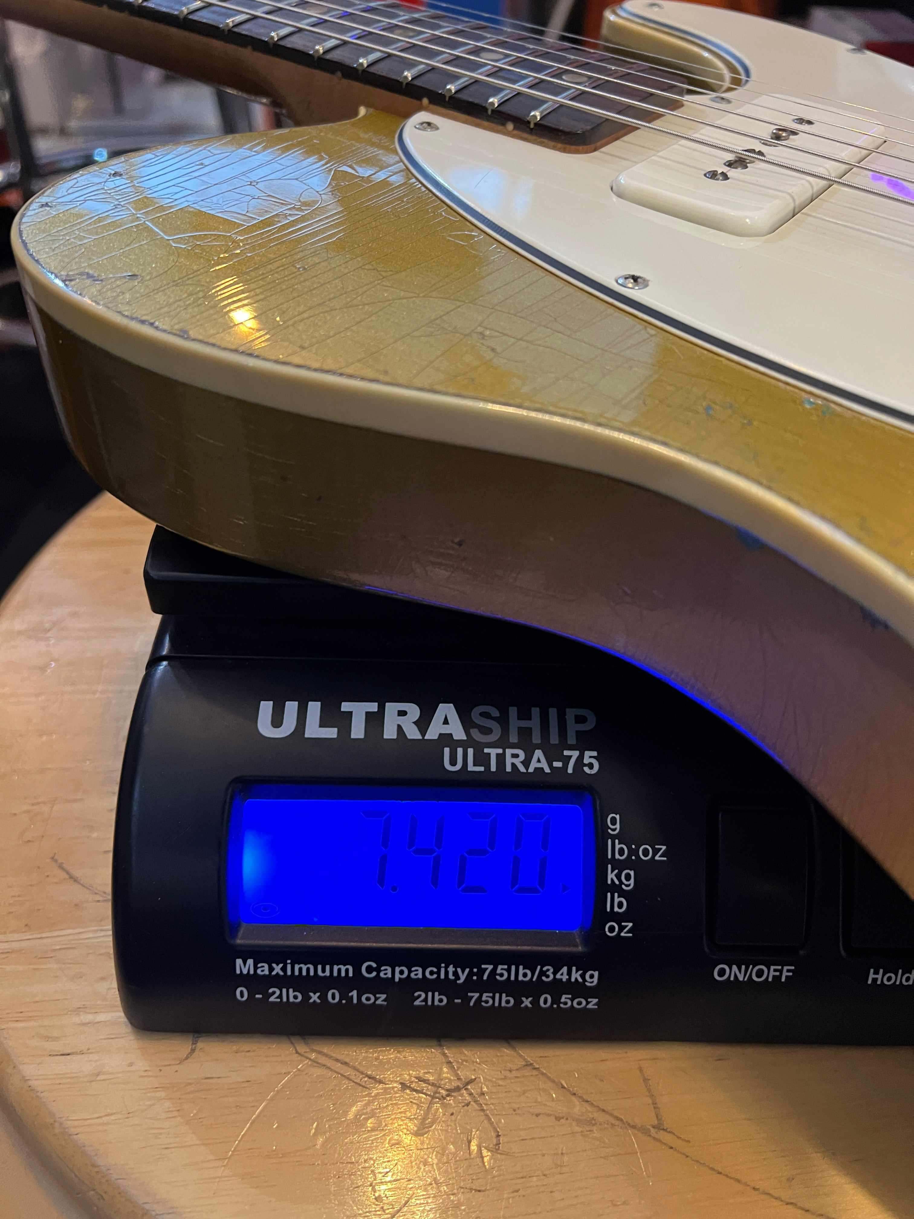 Regent 7 - Duophonic All Gold guitar on a scale showing weight of 7.42 lbs, showcasing its unique design and vintage appeal.