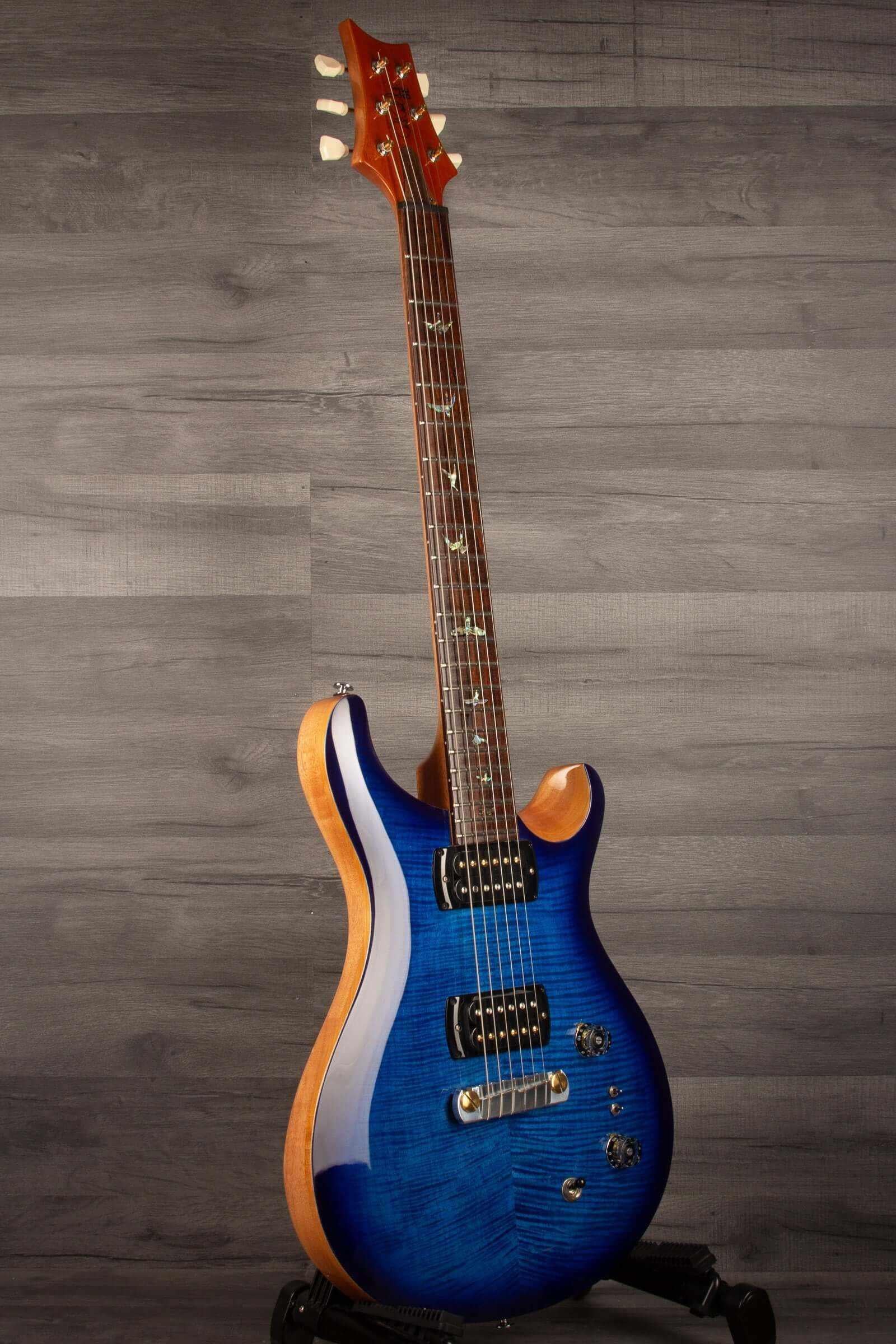 USED - PRS SE Paul’s Guitar Electric Guitar - Faded Blue Burst displayed on a stand with original gig bag.