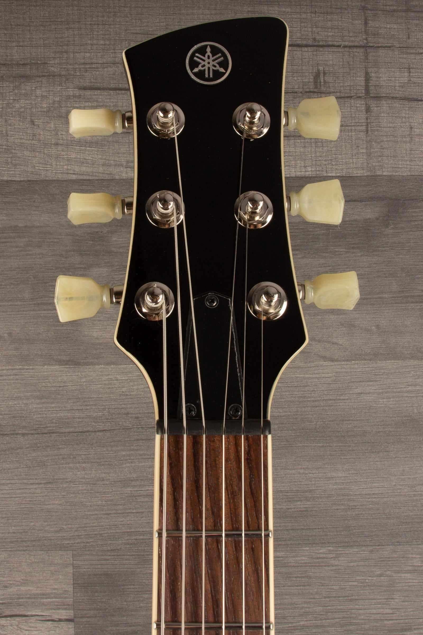 Yamaha RSS02T Revstar - Fire Red guitar headstock showing tuning pegs and logo.