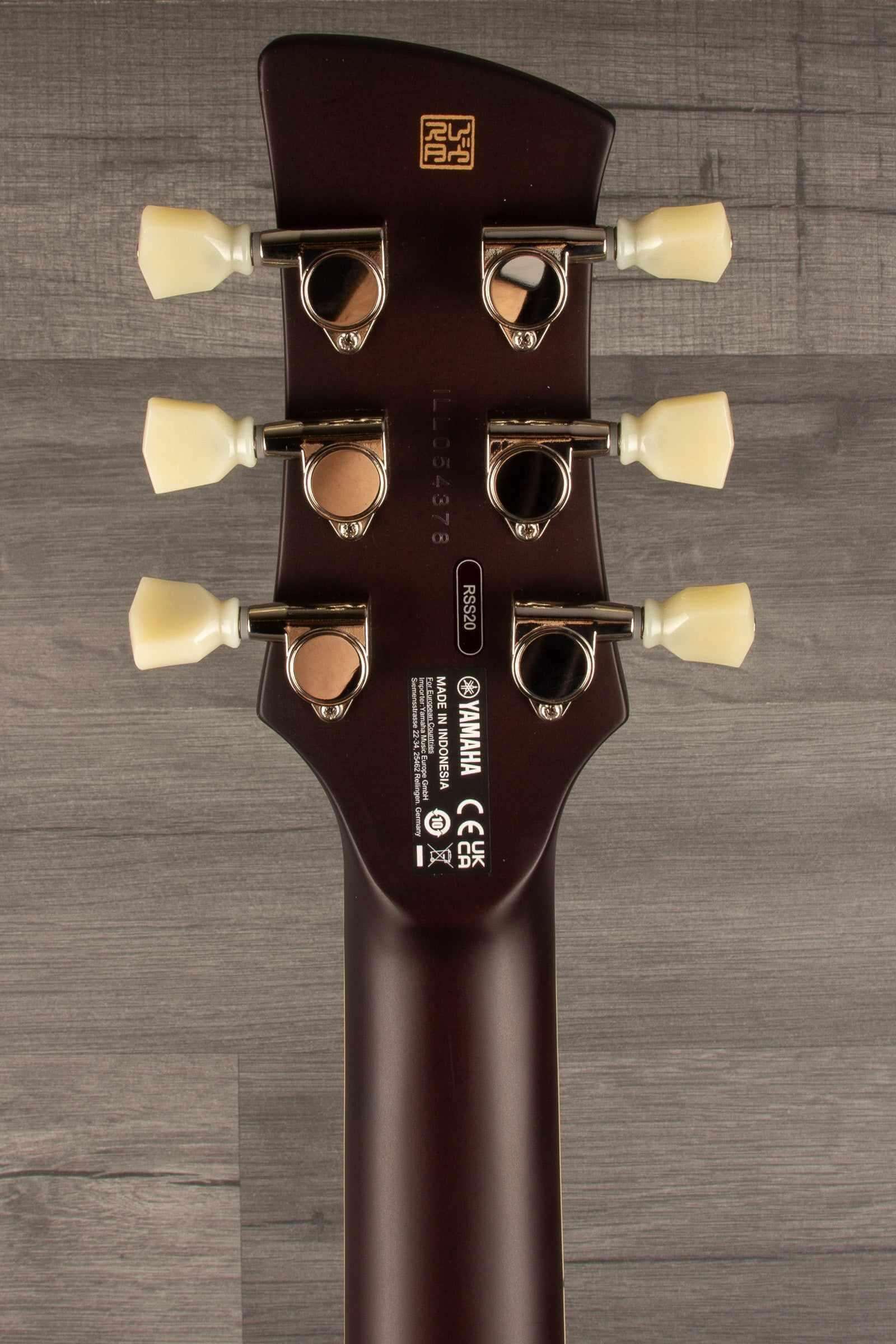 Yamaha RSS20 Revstar -Sonic Blue guitar headstock showing tuning pegs and logo on wood background.