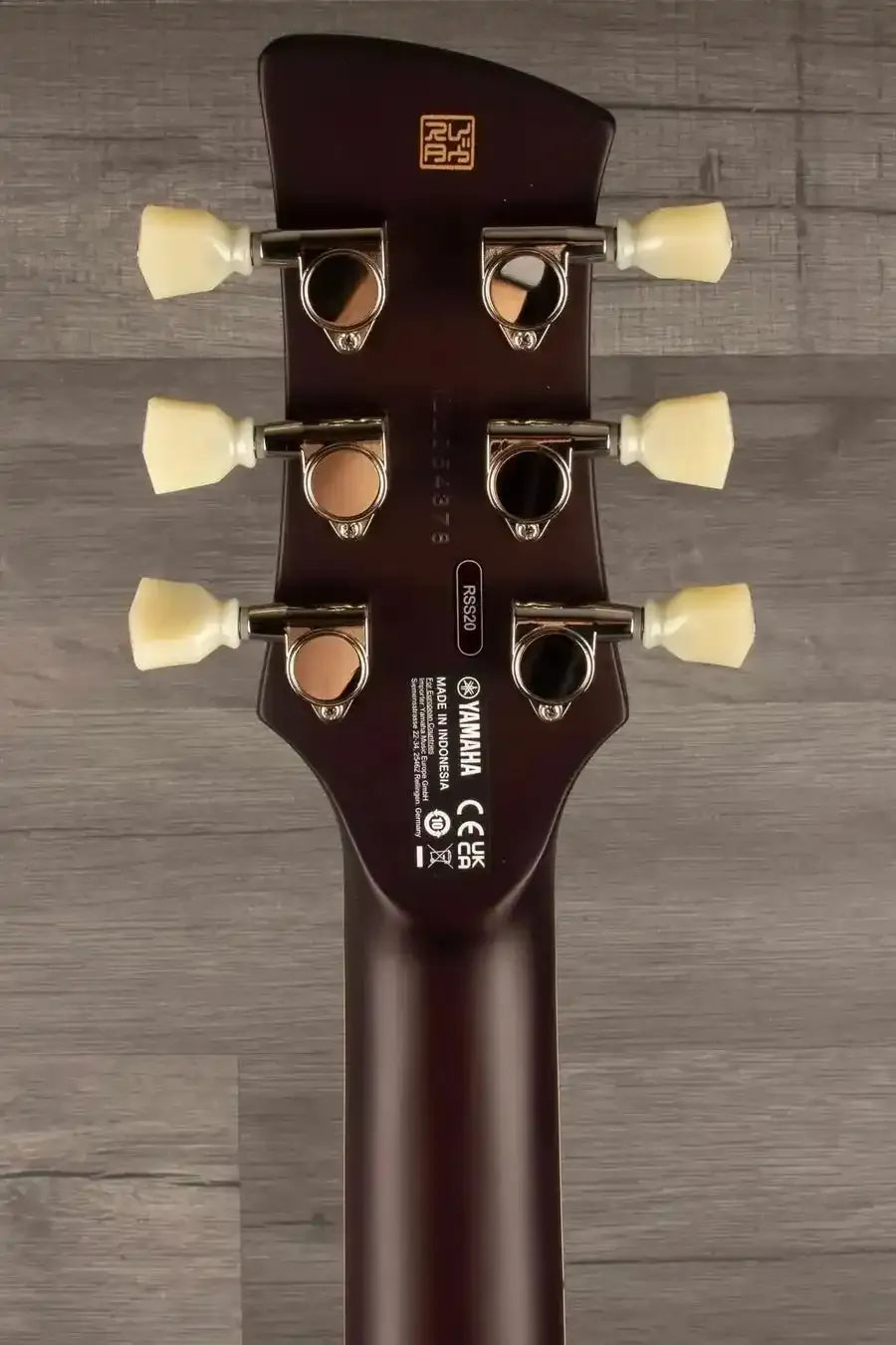 Yamaha RSS20 Revstar -Sonic Blue guitar headstock showing tuning pegs and logo on wood background.