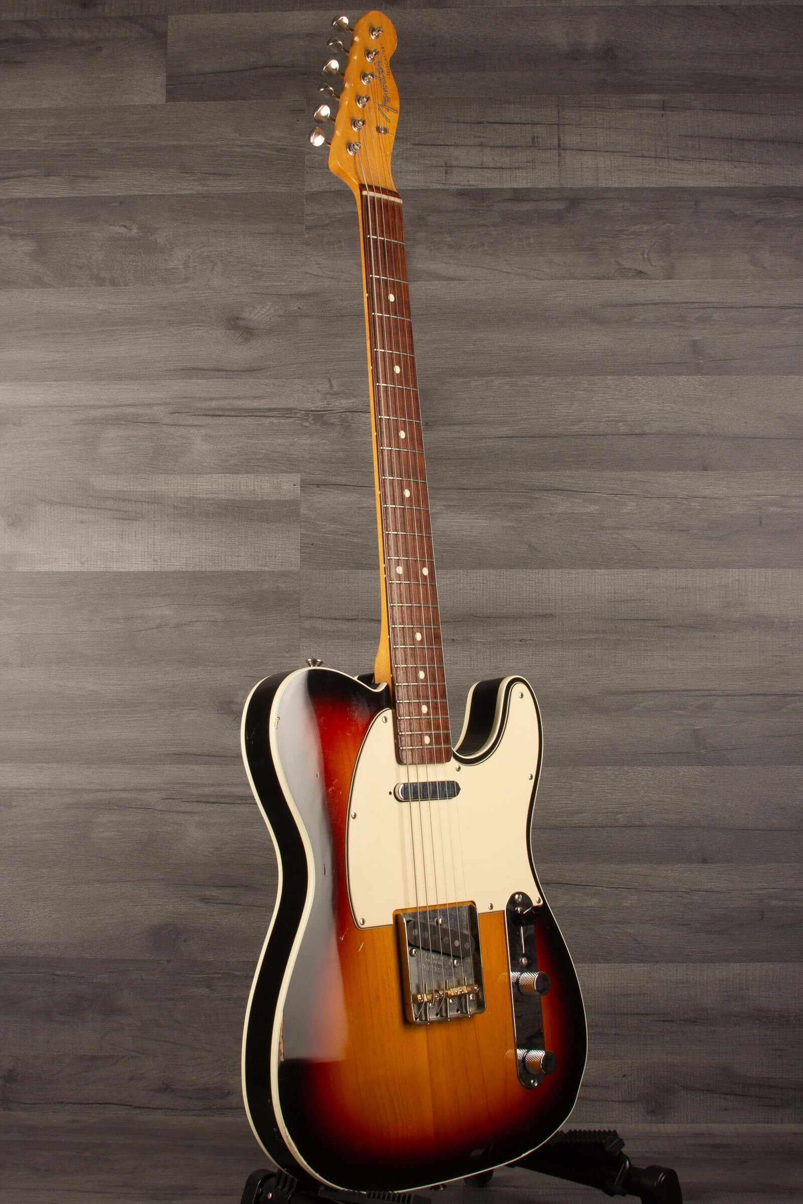 Fender Japanese Traditional II 51 Nocaster used guitar in 3 Tone Sunburst finish standing upright on a grey background.