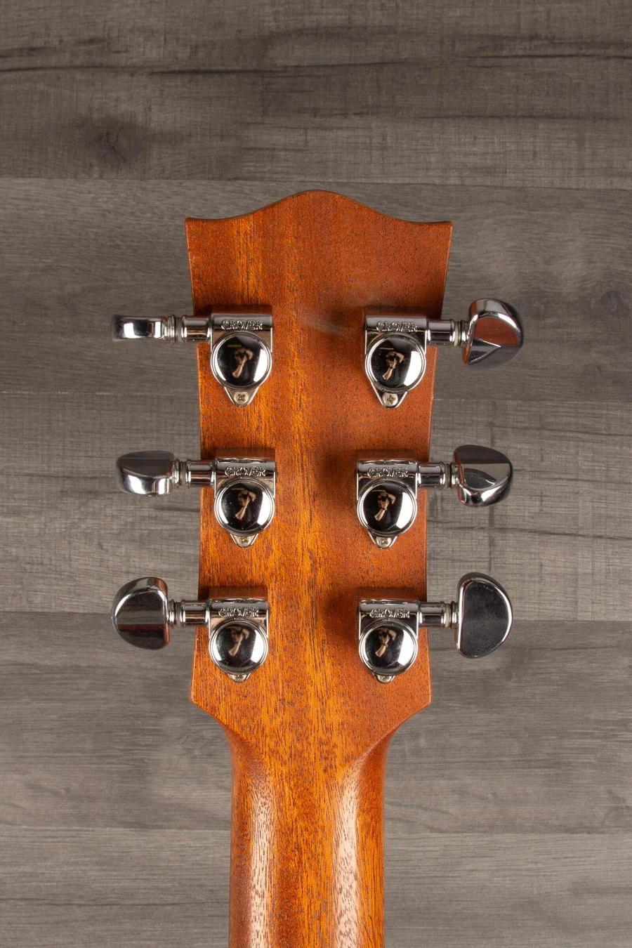 Close-up of the headstock of a Maton M808 guitar showing tuning pegs and polished wood finish.
