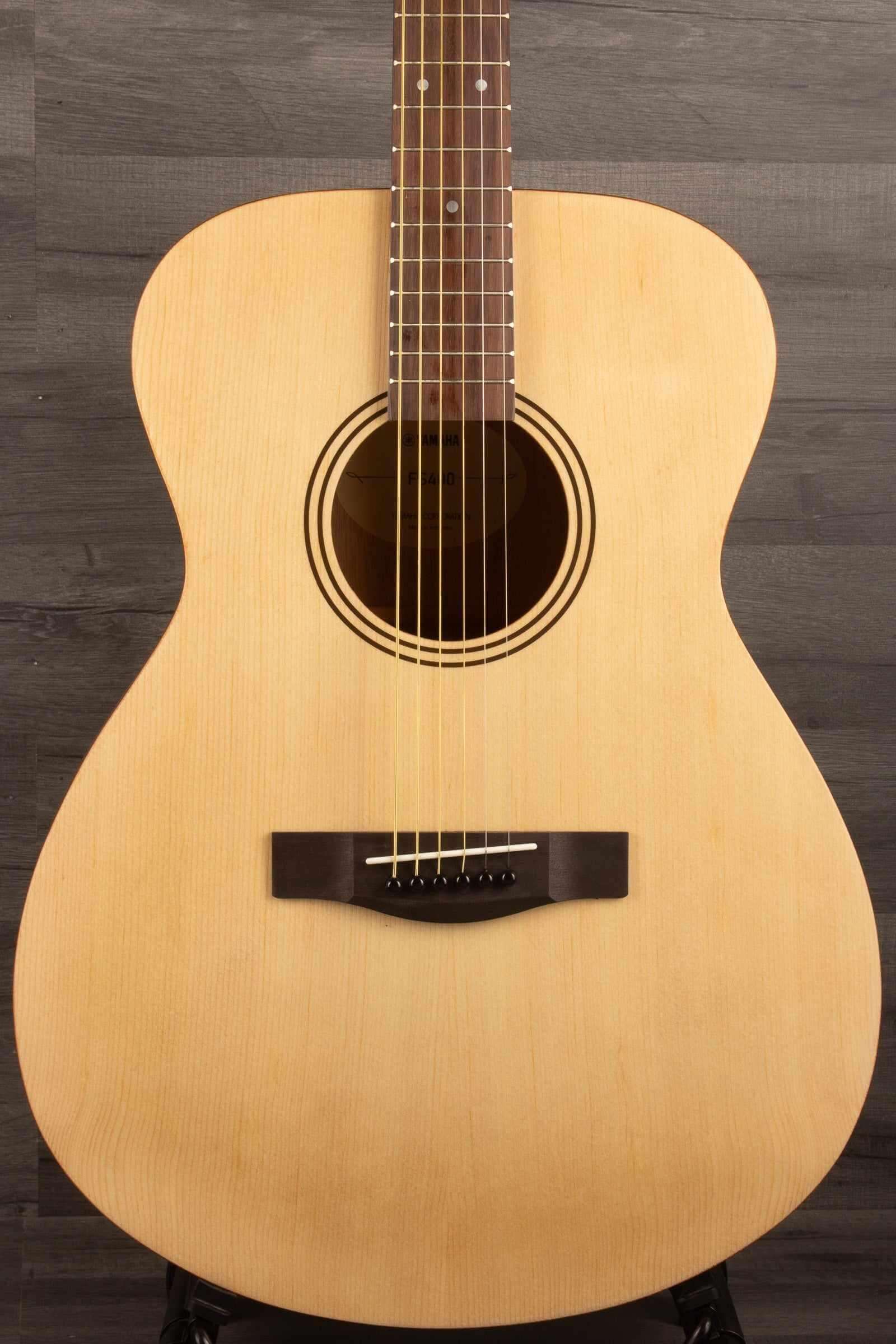 Yamaha FS400 Natural Satin acoustic guitar front view on a wooden surface