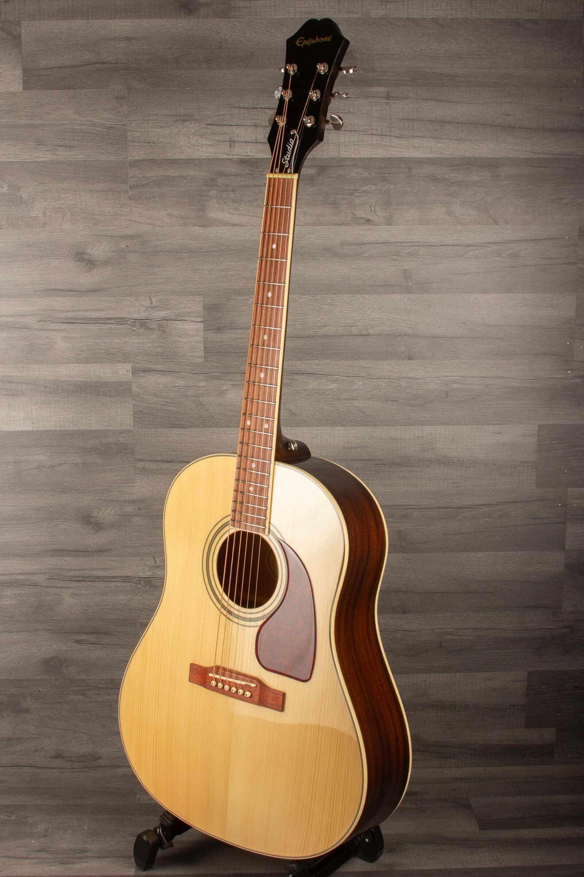 Epiphone J45 Studio Solid Top - Natural, Acoustic Guitar showcased against a wooden backdrop.