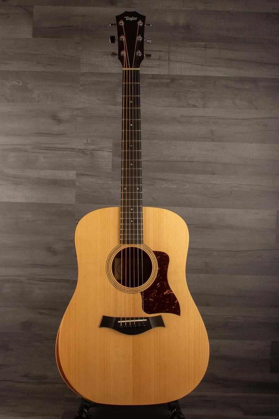 USED - 2022 Taylor 110e acoustic guitar with solid Sitka spruce top and NT neck design on wooden background.