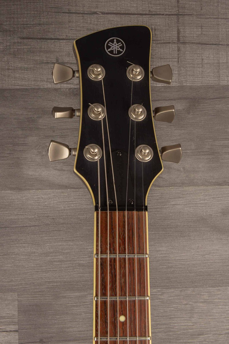 Close-up of the headstock of a USED Yamaha RS502T FMX guitar, showcasing tuning pegs and fingerboard details.