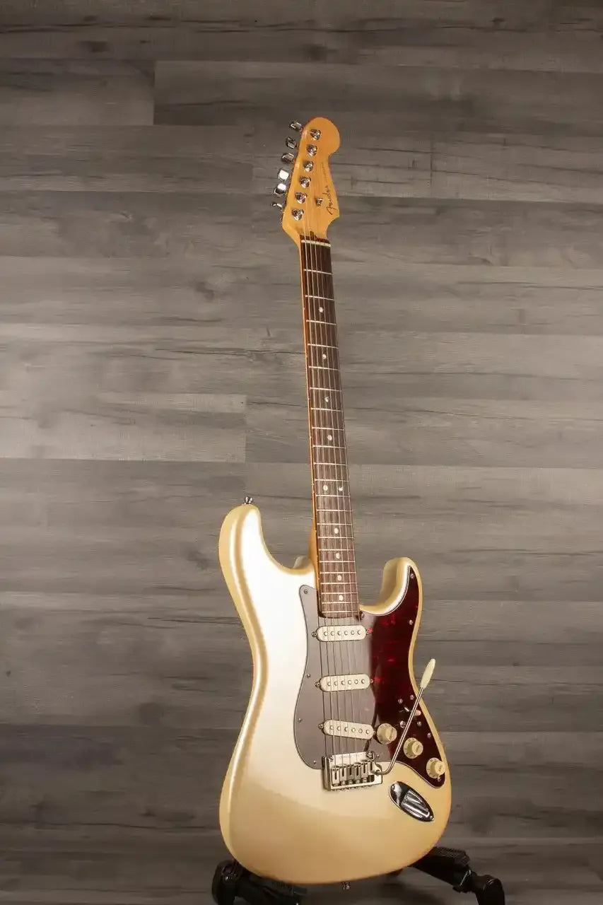 Electric guitar on a stand against a wooden wall