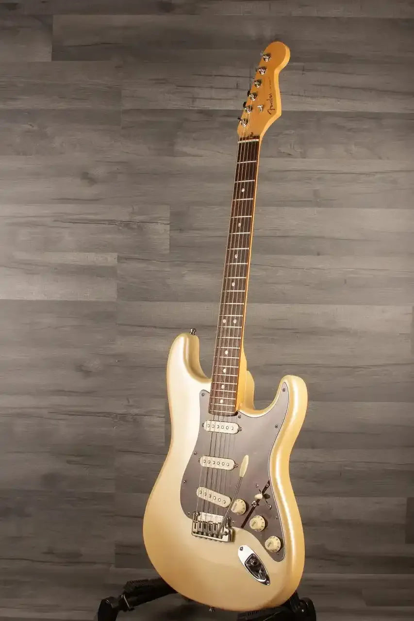 Electric guitar on a stand against a wooden background