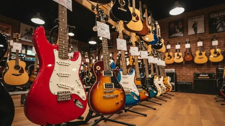 Selection of beginner electric guitars including Squier Sonic Stratocaster and Epiphone Les Paul Special in a guitar shop