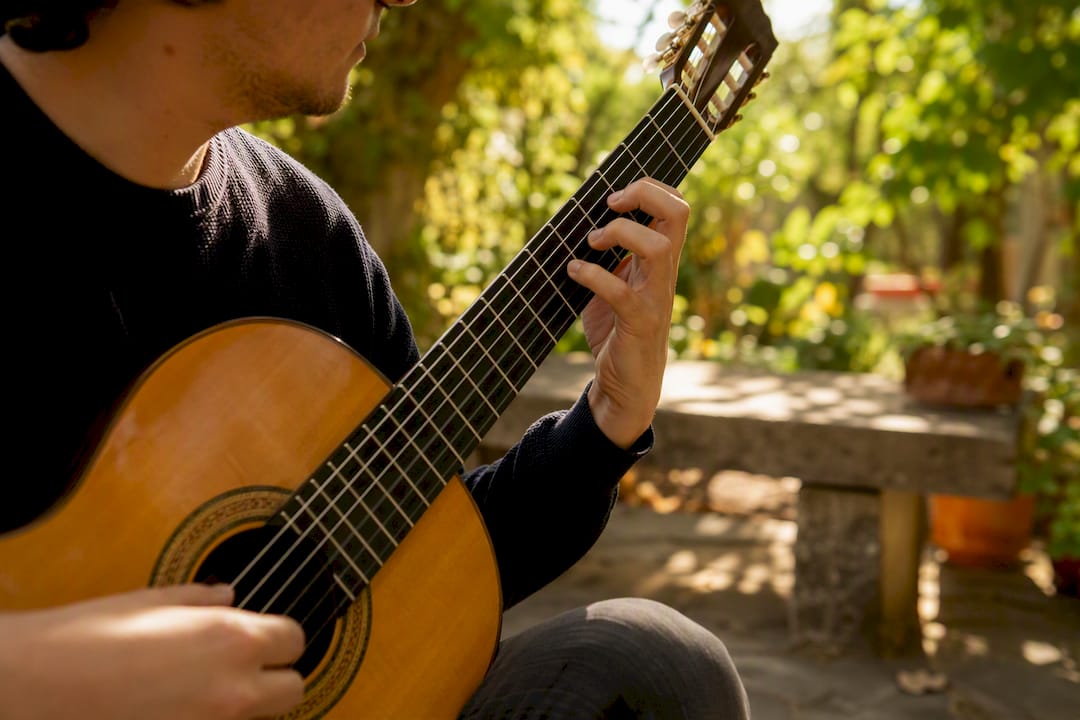 Classical guitarist's fingers on guitar fretboard
