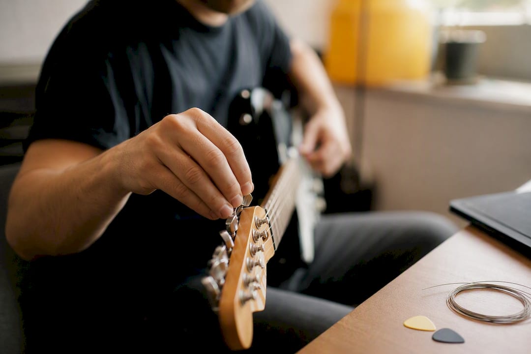 Thumb plucking guitar string during tuning