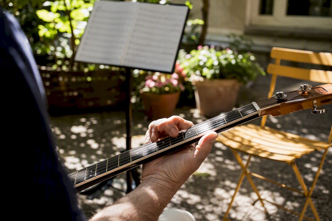 Hands playing guitar while reading sheet music
