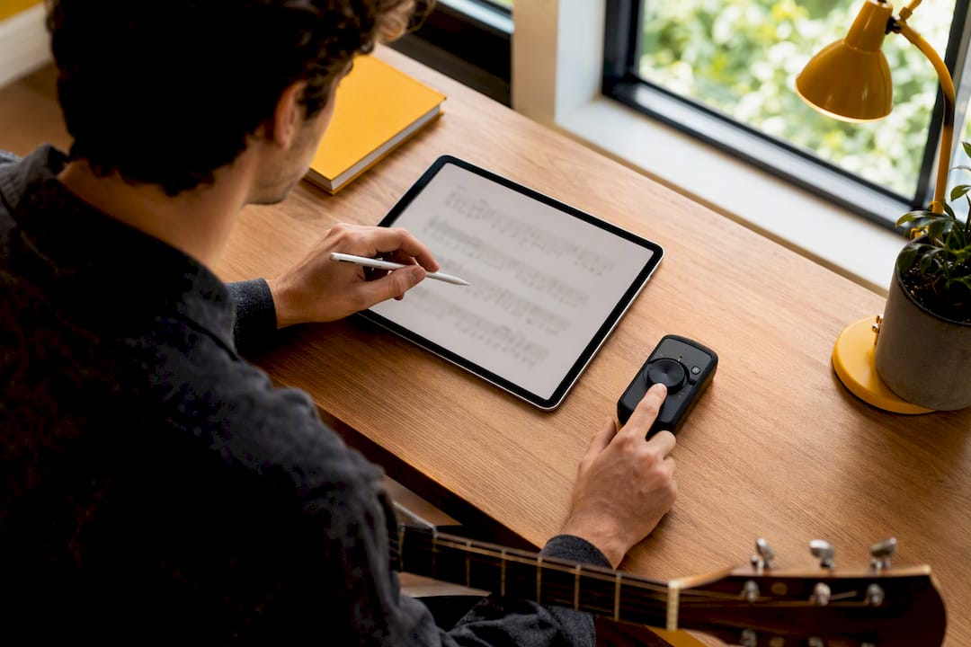 Learner practising guitar tab rhythm with metronome