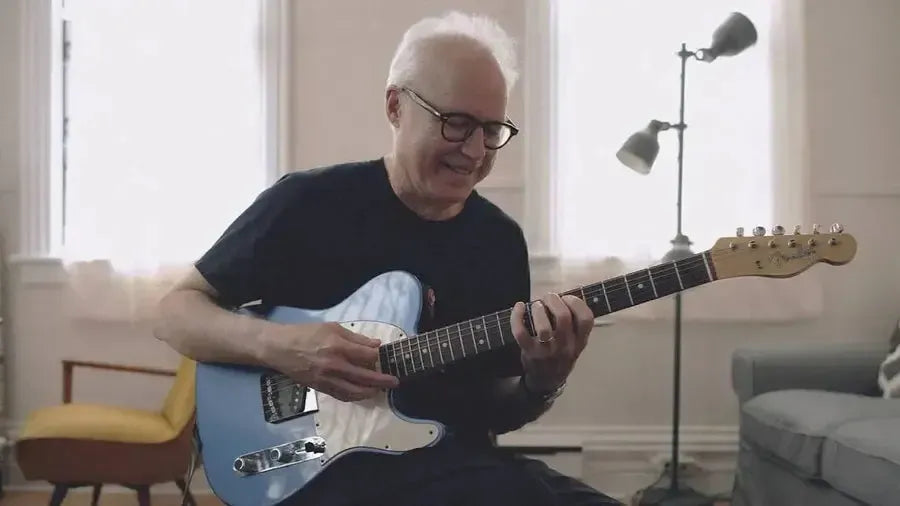 Young adult playing guitar in warm living room