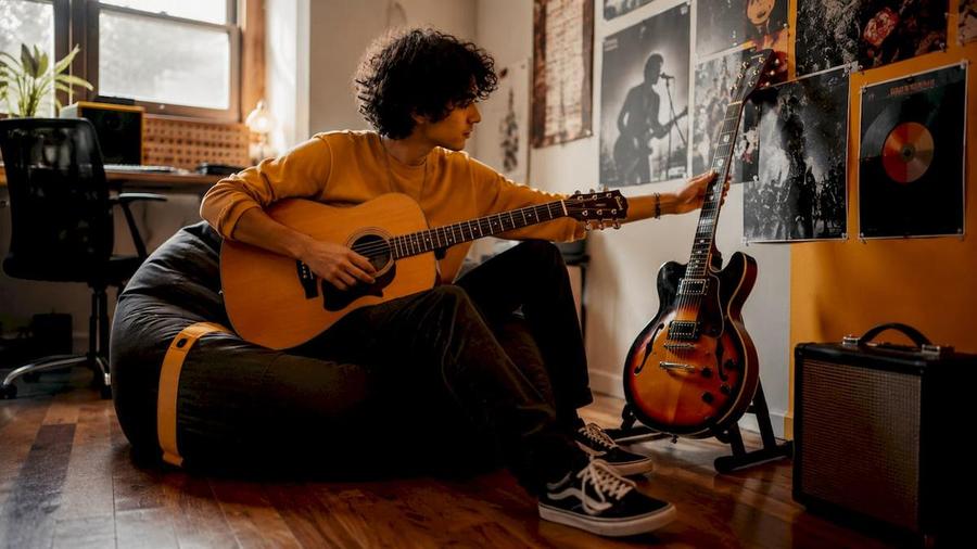 Guitarist comparing acoustic and semi-acoustic guitars