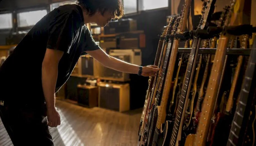 Musician selecting electric guitar in store