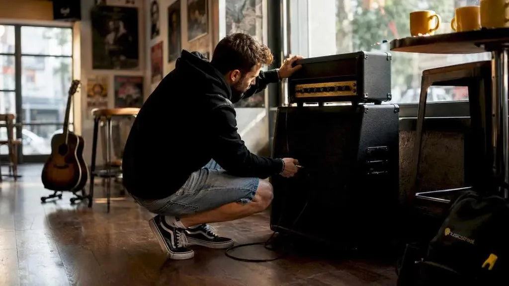 Person connecting amp head to speaker cabinet