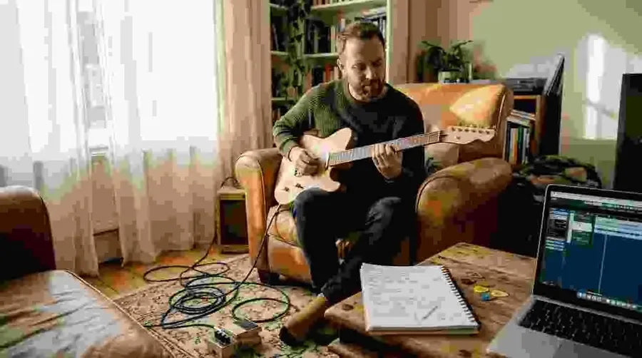 Guitarist playing custom guitar at home