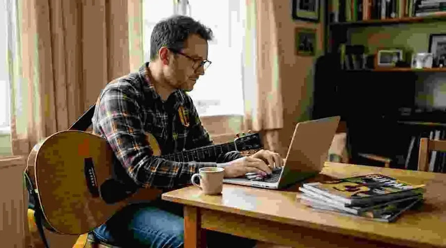 Man researching Martin guitars on laptop at home