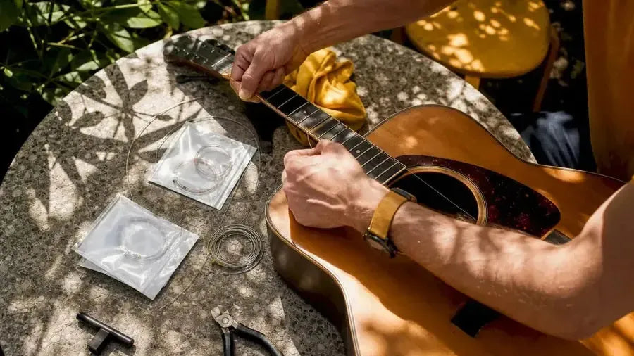 Hands restringing acoustic guitar with bronze strings
