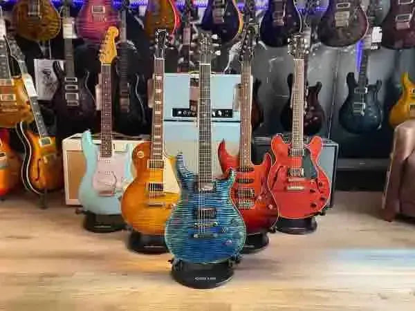 Six electric guitars displayed in a music store, featuring various colors and styles.