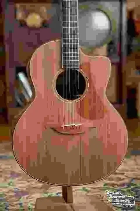 Guitarist on couch showing acoustic cutaway
