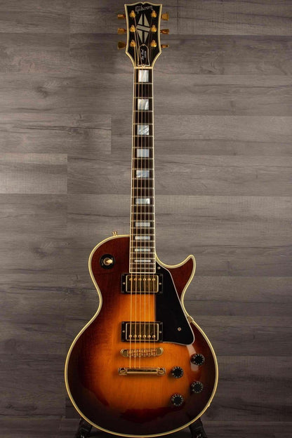 USED - Gibson 1982 Les Paul Custom - Antique sunburst beautifully showcased on a wooden background.