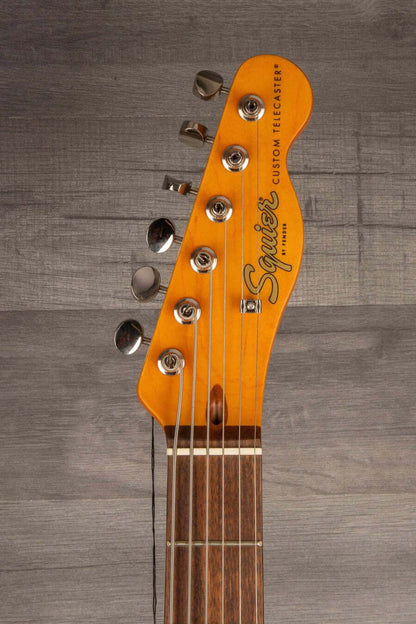 Squier Classic Vibe Baritone Custom Telecaster guitar headstock with strings and tuning pegs.