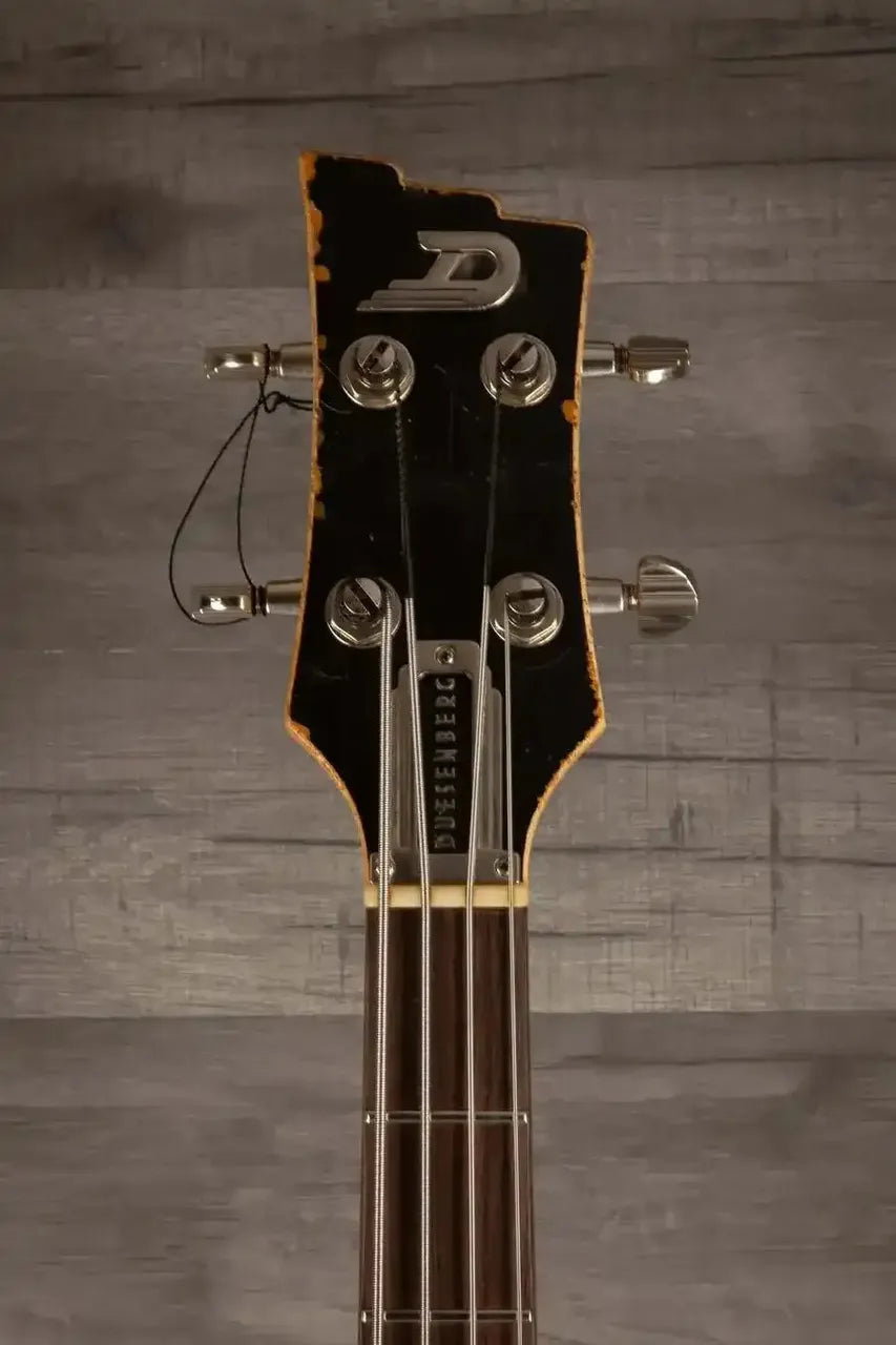 Duesenberg Chris Chaney Bass Black Distressed LTD headstock featuring vintage design and aged finish.