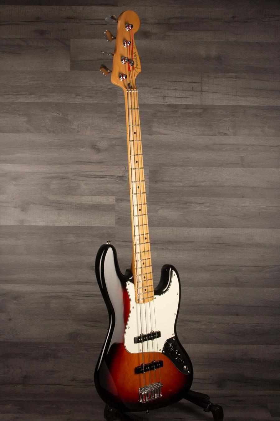 Fender Player Jazz Bass Guitar, Maple neck, 3 tone sunburst on a gray background.