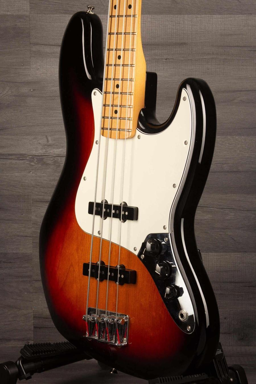 Fender Player Jazz Bass Guitar, Maple neck, 3 tone sunburst on display with a sleek finish and detailed craftsmanship.