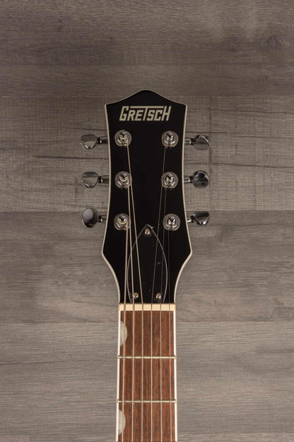 Gretsch G5230T Electromatic Sparkle Jet guitar headstock with tuning pegs and logo on a wooden background.