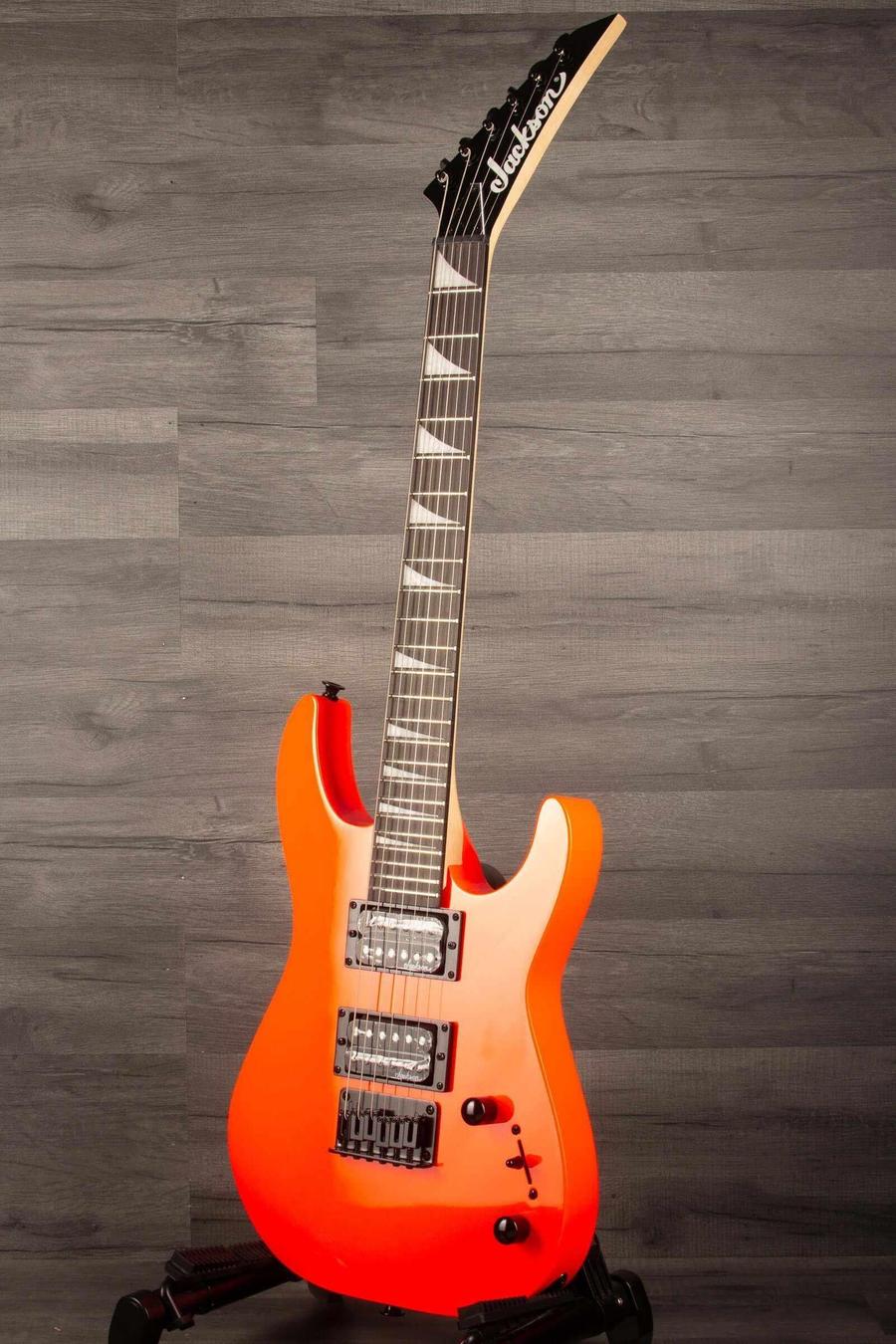 Jackson  JS Series Dinky® Minion JS1X, Amaranth Fingerboard, Safety Orange displayed on a stand.