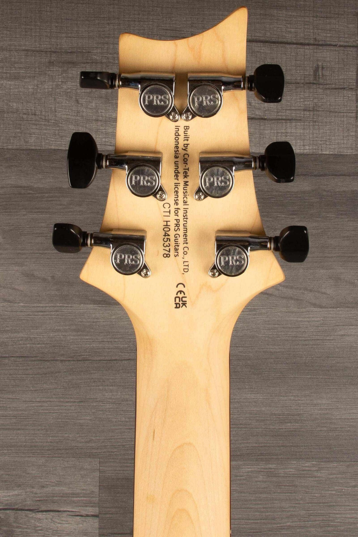 Back of PRS SE CE24 Standard Stoptail guitar neck showing tuning pegs and logo detail.