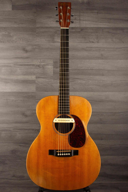 USED - Martin 000X1 inc LR Baggs M1 & hard case displayed on a stand against a gray background.