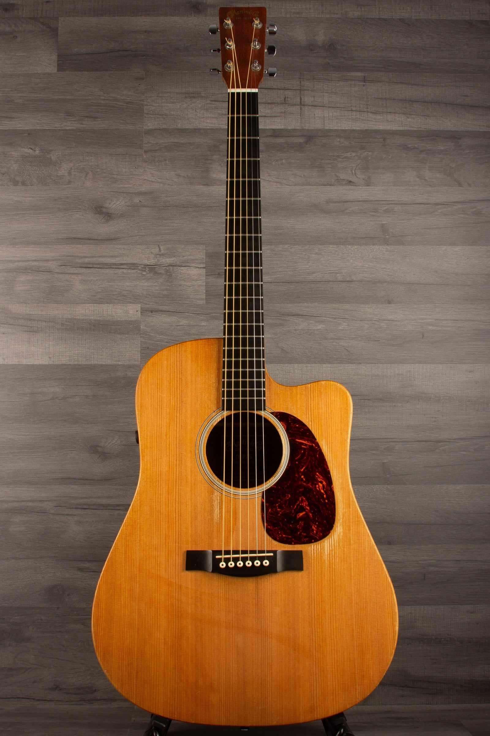 USED - Martin - DCPA5 Performing Artist Dreadnought inc hard case displayed on a stand with a wooden background.