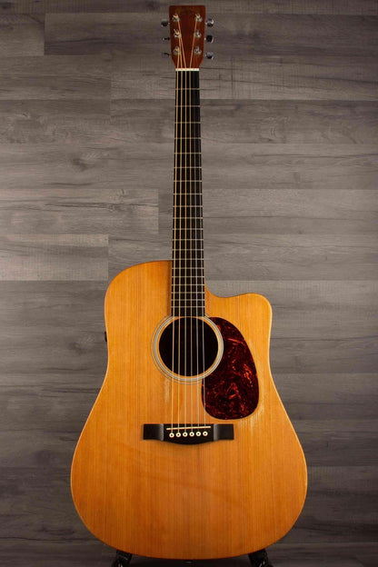 USED - Martin - DCPA5 Performing Artist Dreadnought inc hard case displayed on a stand with a wooden background.