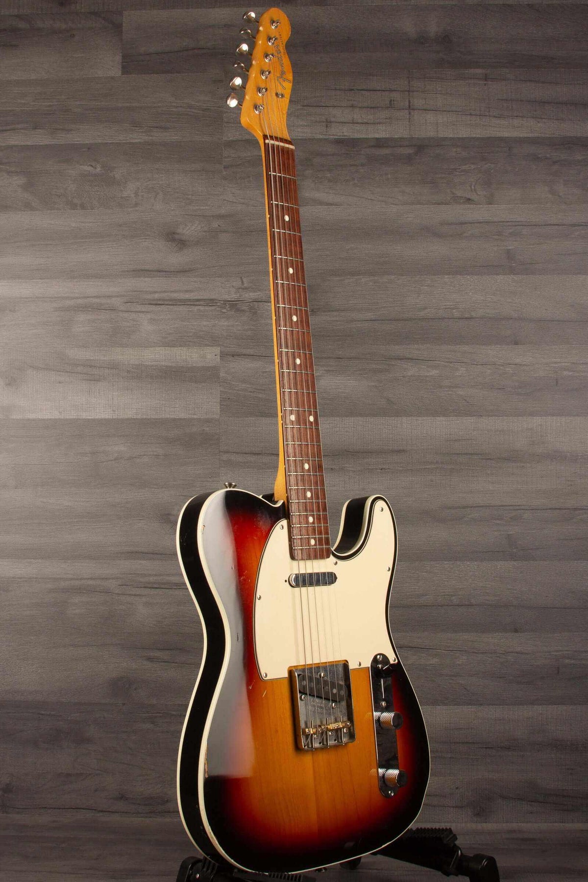 Fender Japanese Traditional II 51 Nocaster used guitar in 3 Tone Sunburst finish standing upright on a grey background.