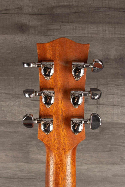 Close-up of the headstock of a Maton M808 guitar showing tuning pegs and polished wood finish.