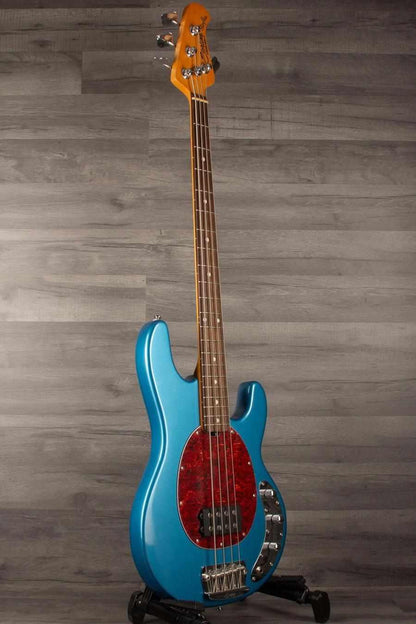 USED - Sterling by Music Man Stingray Ray24 Bass Guitar - Toluca Lake Blue on display with vintage body design.
