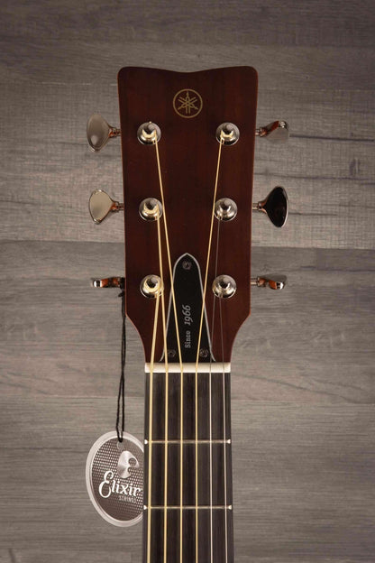 Yamaha FSX3 II guitar headstock with tuning pegs and Elixir tag on a wooden background.